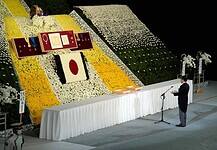 Tüntetés és katonai tiszteletadás Sindzó temetésén